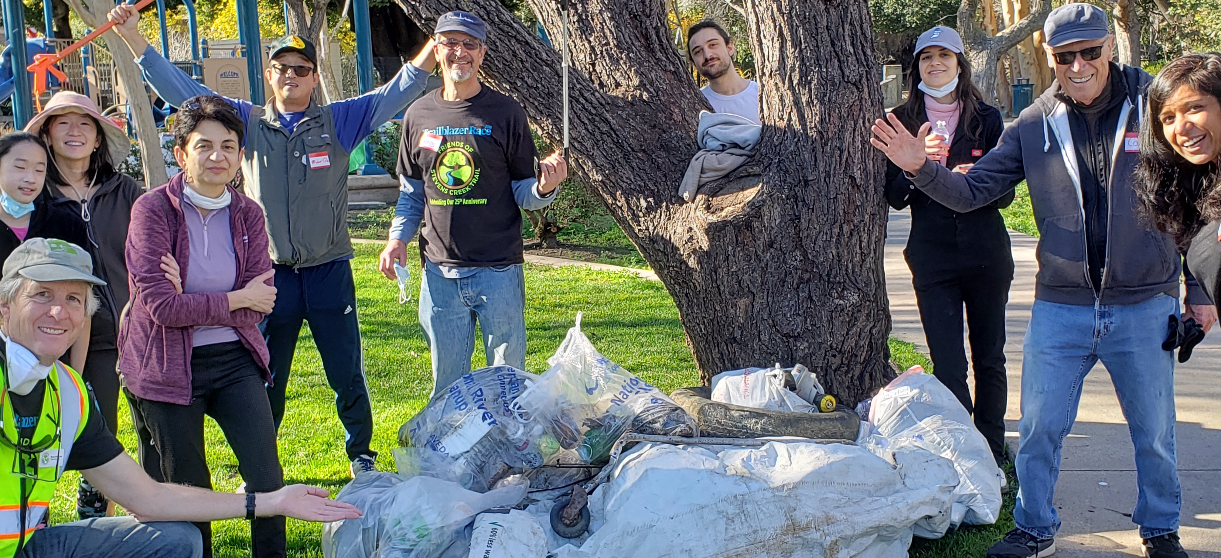 Group poses with their collected trash pile